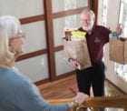 A volunteer delivers groceries to a patient